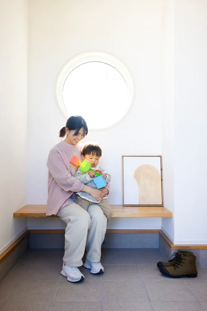 丸窓の玄関とベンチ